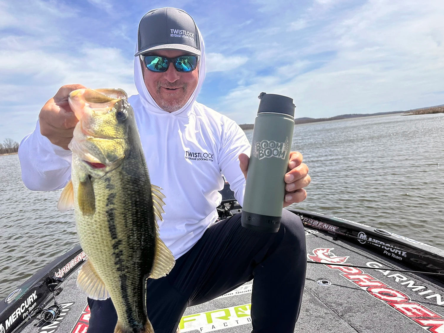TwistLock Ambassador Professional Angler Fred Roumbanis on his bass boat holding a fish and his insulated stainless steel green canteen.
