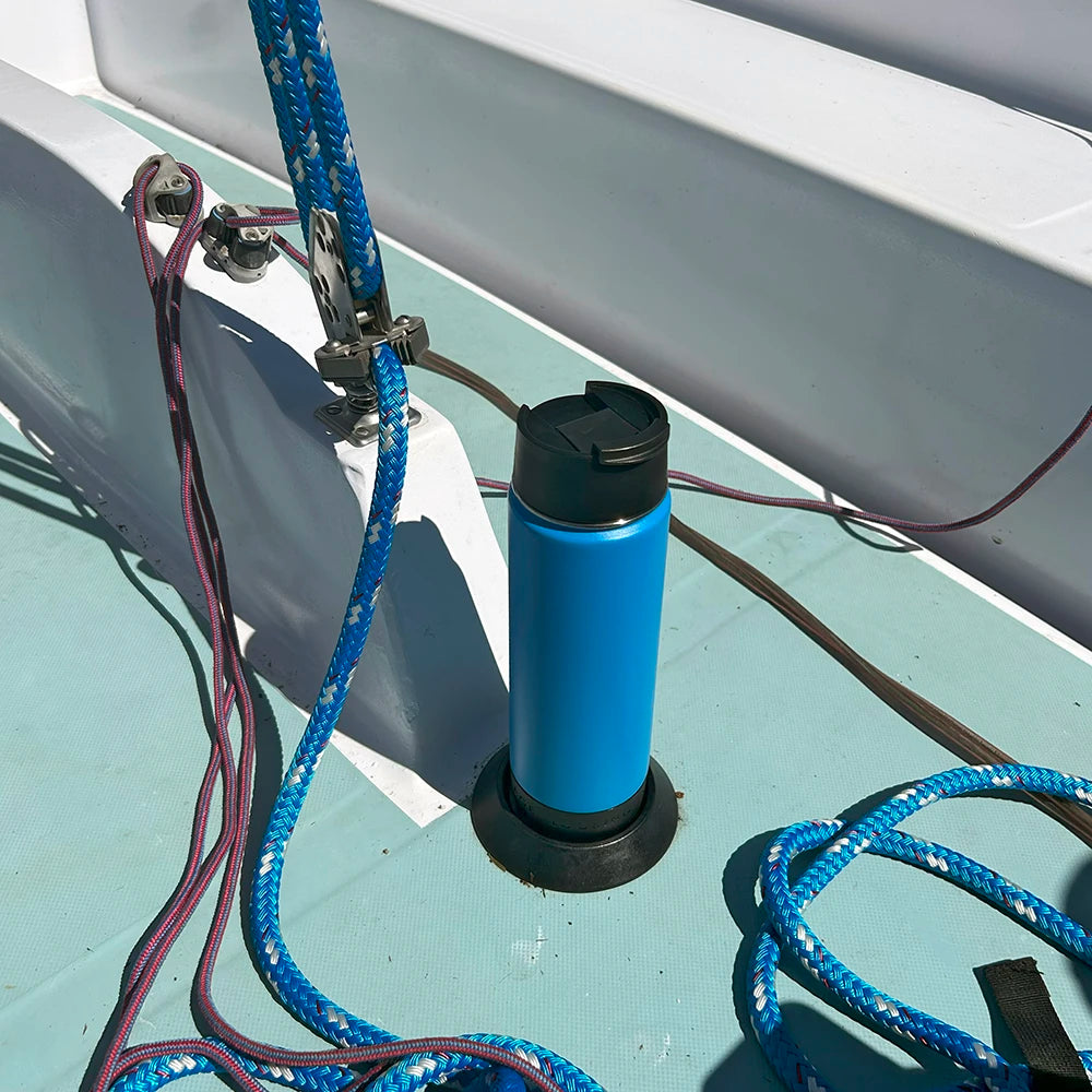 A TwistLock attachable secure flat mount marine cup holder and insulated canteen on the deck of a sailboat.