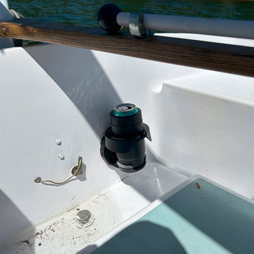 A close up of a marine TwistLock Vertical Mount folding, attachable cup holder and insulated can cooler on a sailboat near the tiller.