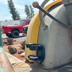 A side view of the Vertical Mount Locking Cup Holder attached to a excavator in the open position. 