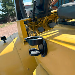 Vertically mounted folding cup holder attached to the side of a forklift in the open position.