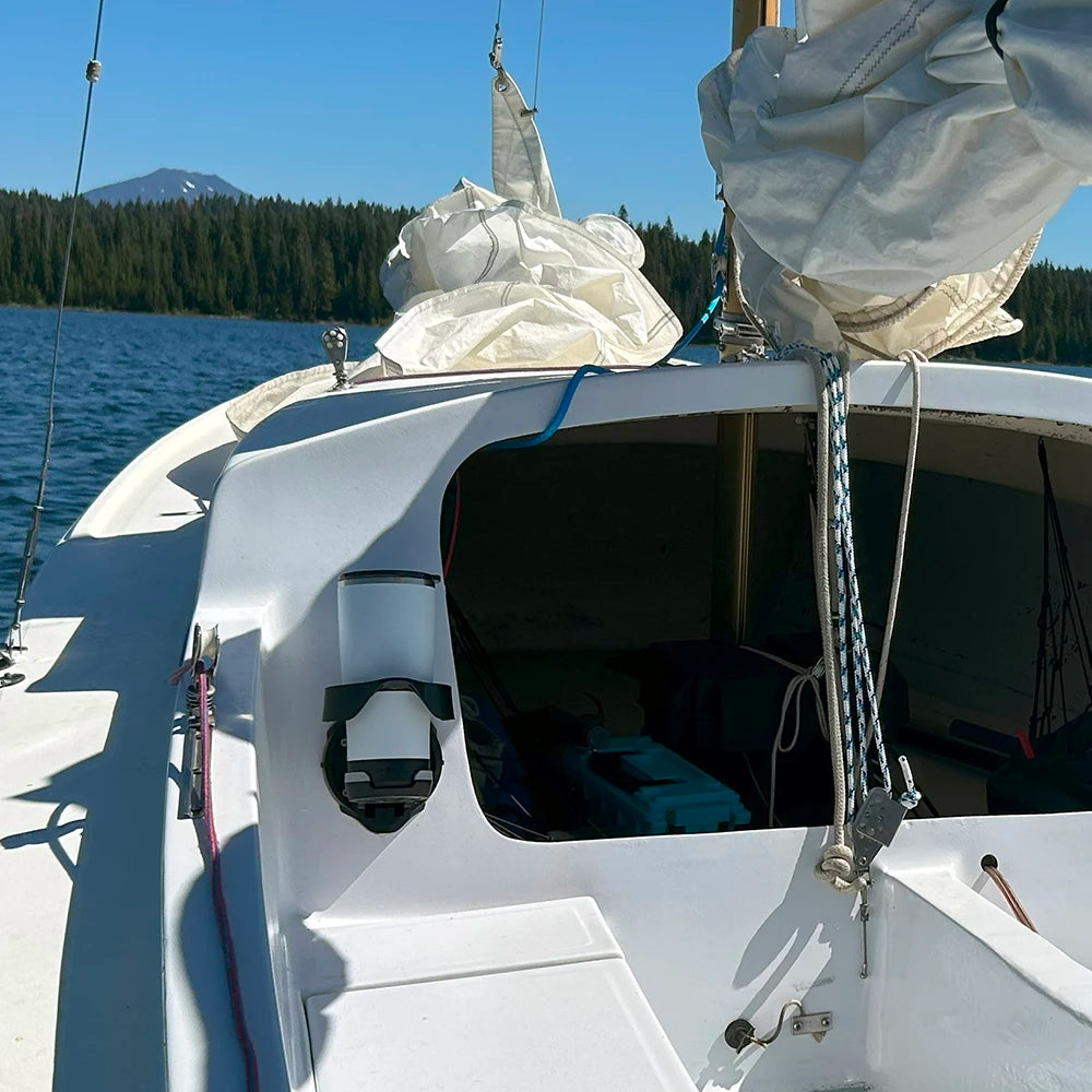 Sailboat with a TwistLock Vertical Mount attachable cup holder and insulated tumbler on a lake with mountains in the background